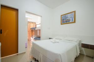 佩尼亚Hotel Penha的白色的卧室配有一张床,墙上挂着一幅画