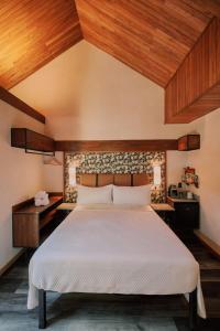 福尔图纳Suwa Villa Arenal的一间卧室设有一张大床和木制天花板。