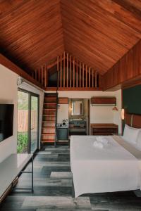 福尔图纳Suwa Villa Arenal的卧室设有白色大床和木制天花板。