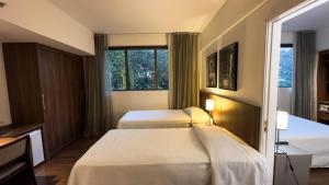 贝洛奥里藏特Hotel Vivenzo Savassi Belo Horizonte的酒店客房设有两张床和窗户。