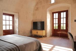 阿雷基帕Estancia El Solar的一间卧室配有一张床和一台平面电视