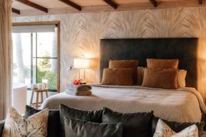 佩里吉安比奇努萨维巴湖屋舍酒店的一间卧室设有一张大床和一个大窗户