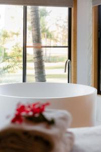 佩里吉安比奇努萨维巴湖屋舍酒店的一间带白色浴缸和窗户的浴室