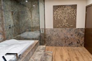 坎莫尔Luxury suite with Sauna and Spa Bath - Elkside Hideout B&B的带淋浴和浴缸的浴室