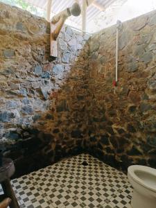 武吉拉旺back to nature ecotourism的石质浴室设有卫生间和 ⁇ 格地板