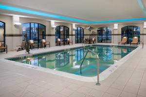 奇克托瓦加水牛城机场万豪万怡酒店的一座配有桌椅的酒店游泳池