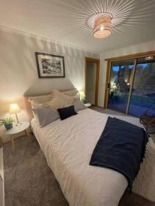 SwanpoolBogaroo Cottage的一间卧室配有一张大床和一个吊灯。