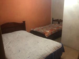 洛哈Pensión Malacatos的一间客房内配有两张床的房间