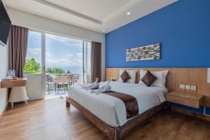 蓝梦岛The Tanis Beach Resort Nusa Lembongan的一间卧室设有一张蓝色墙壁的大床