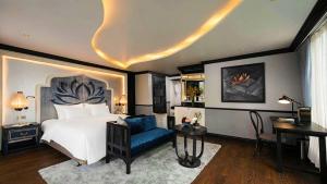 下龙湾Lotus Elegance Cruise的一间卧室配有一张床、一把椅子和一张书桌