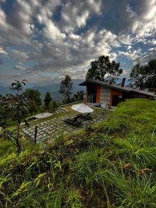 博卡拉Deumadi Mountain Cottage的坐在草山顶上的房子