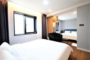 统营市De Lamour Hotel的酒店客房设有两张床和窗户。
