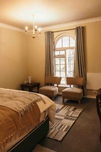 BalgowanMilestone Farm House的一间卧室配有一张床、两把椅子和一个窗户