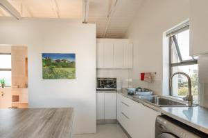 开普敦Vlei Cove的厨房配有白色橱柜和水槽