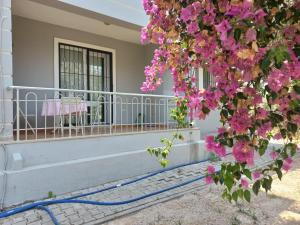 费特希耶Perfect Holiday Condo at Central Fethiye Best for Families的前廊上一座鲜花粉红色的房子