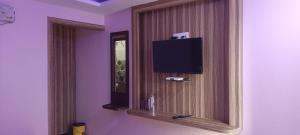 布莱尔港Hotel Vedant的一间设有镜子和墙上电视的房间