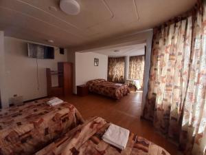 普诺HOSTAL SUMITA HOUSE_INN的一间设有两张床的客房和一间设有窗帘的客房