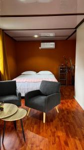 乌图罗阿Rupe Rupe Lodge的一间卧室配有一张床、一张沙发和一张桌子