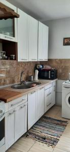 PromnikDomek - Leśna Kryjówka的厨房配有白色橱柜和水槽