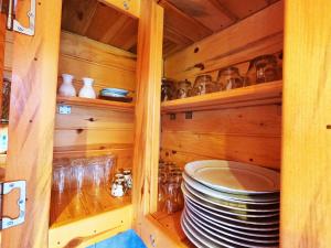 里泽Necran Bungalow اكواخ ايدر的木柜,上面有盘子和玻璃杯