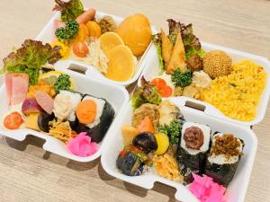 东京hotel MONday Haneda Airport的四个塑料容器,装有不同种类的食物