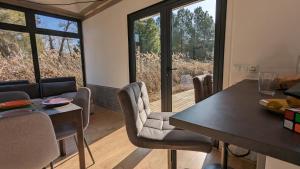 卡斯特尔德费尔斯CoolTainer retreat: Sustainable Coastal forest Tiny house near Barcelona的一间带桌椅和窗户的用餐室