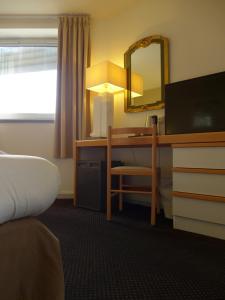 卢尔德天堂酒店的酒店客房配有书桌和镜子