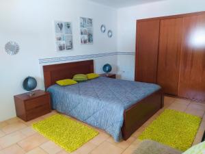 圣马蒂纽·杜·波特Casa da Nelita的一间卧室配有一张带两个黄色枕头的床