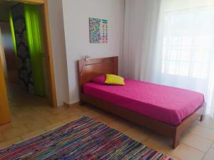 圣马蒂纽·杜·波特Casa da Nelita的一间卧室配有一张带粉色毯子的床和窗户。