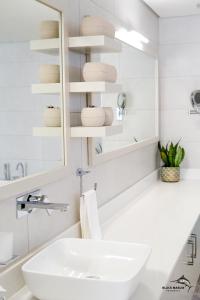 佩雷贝勒Black Marlin Apartments的白色的浴室设有水槽和镜子