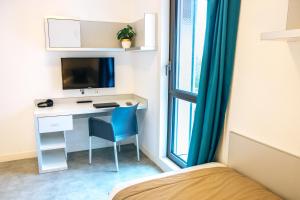 阿斯克新城Twenty Business Flats Lille Grand Stade的一间卧室配有一张带蓝色椅子的桌子和一张床