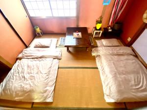 小豆岛星ノソラ的客房设有两张床、一张桌子和一张桌子。