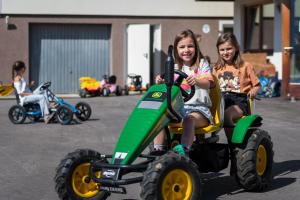 TerfensFerienwohnungen Plattnerhof的两个女孩骑玩具拖拉机