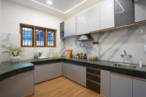 科代卡纳尔Le Mistral, Kodai - Luxury Villa的厨房配有白色橱柜和黑色台面