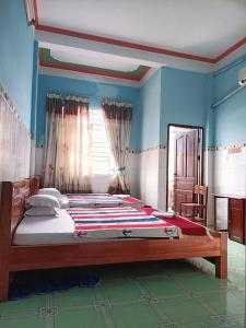 芹苴Khách sạn Ngọc Mai 2的卧室设有一张大床,拥有蓝色的墙壁