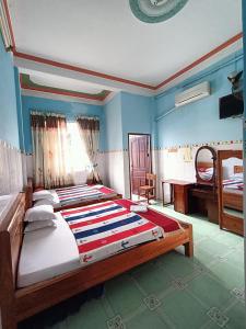 芹苴Khách sạn Ngọc Mai 2的一间卧室配有一张大床和一张书桌