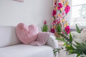 罗瓦涅米City Holiday Apartments 2的坐在白色沙发上的粉红色充气的心