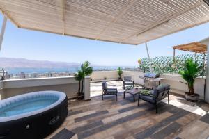 埃拉特Desert and Sea-penthouse Full Sea view的一间客厅,在屋顶上设有按摩浴缸