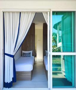 波德申Solesor Kampong Beach Resort的一间卧室设有一张床和一个滑动玻璃门