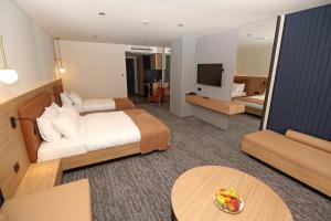 Yomraİnanlar City Hotel的酒店客房,配有床和电视