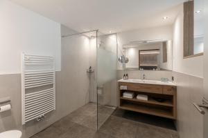 奥蒂塞伊Hotel Niblea Dolomites的一间带水槽和玻璃淋浴的浴室