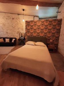 昂斯Chamade en Beaujolais的卧室设有一张砖墙内的大床