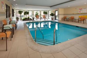 哈里斯堡哈里斯堡赫氏万怡酒店的酒店大堂的游泳池,配有桌椅