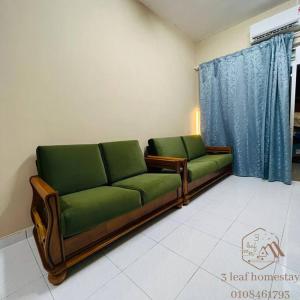 古来Jalan Sena Indahpura Landed House的一间客厅,在房间内配有两张绿色沙发