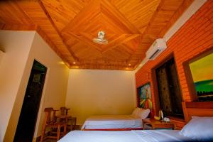 峰牙Sườn Đồi Bungalow Homestay的一间卧室设有两张床和木制天花板