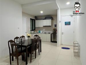 古晋Staycation Homestay 14 P Residence kuching condo的厨房以及带桌椅的用餐室。