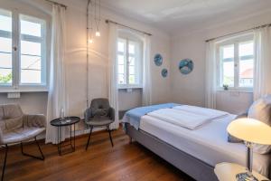 索梅拉Villa Sommerach的一间卧室配有一张床、两把椅子和窗户