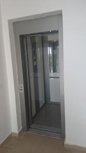 都拉斯Sunlit Coast Apartment Durrës的大楼内带玻璃门的走廊