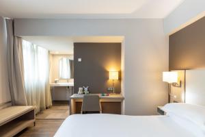 马赛AC Hotel by Marriott Marseille Prado Vélodrome的配有一张床和一张书桌的酒店客房