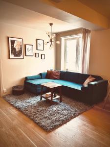 奥斯陆Magnificent Modern Apartment Central Oslo的客厅配有蓝色的沙发和桌子